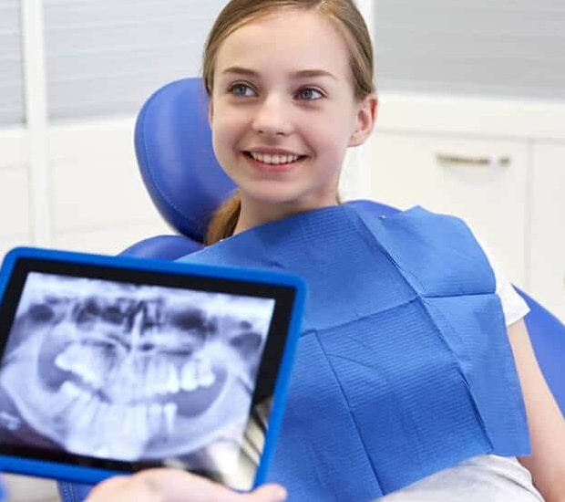 teenage girl checking bi-annual checkup with dentist